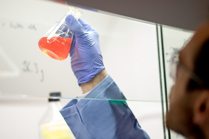 Chemist looking at liquid in a beaker